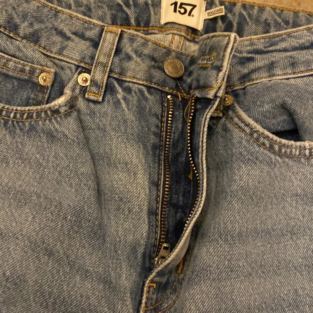 Säljer ett par snygga blå jeans från 157 i storlek XS. De har en cool, sliten look med hål på knäna och en avslappnad passform. Perfekta för en casual stil! 🕶️. Jeans & Byxor.