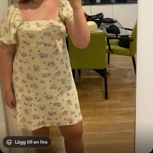 Gul blommig klänning från Mango  - Söt gul klänning med blommigt mönster från MNG. Den har korta puffärmar och en smickrande passform. Perfekt för sommarens fester eller en mysig picknick i parken. Klänningen är i mycket bra skick och redo för nya äventyr! 🌼