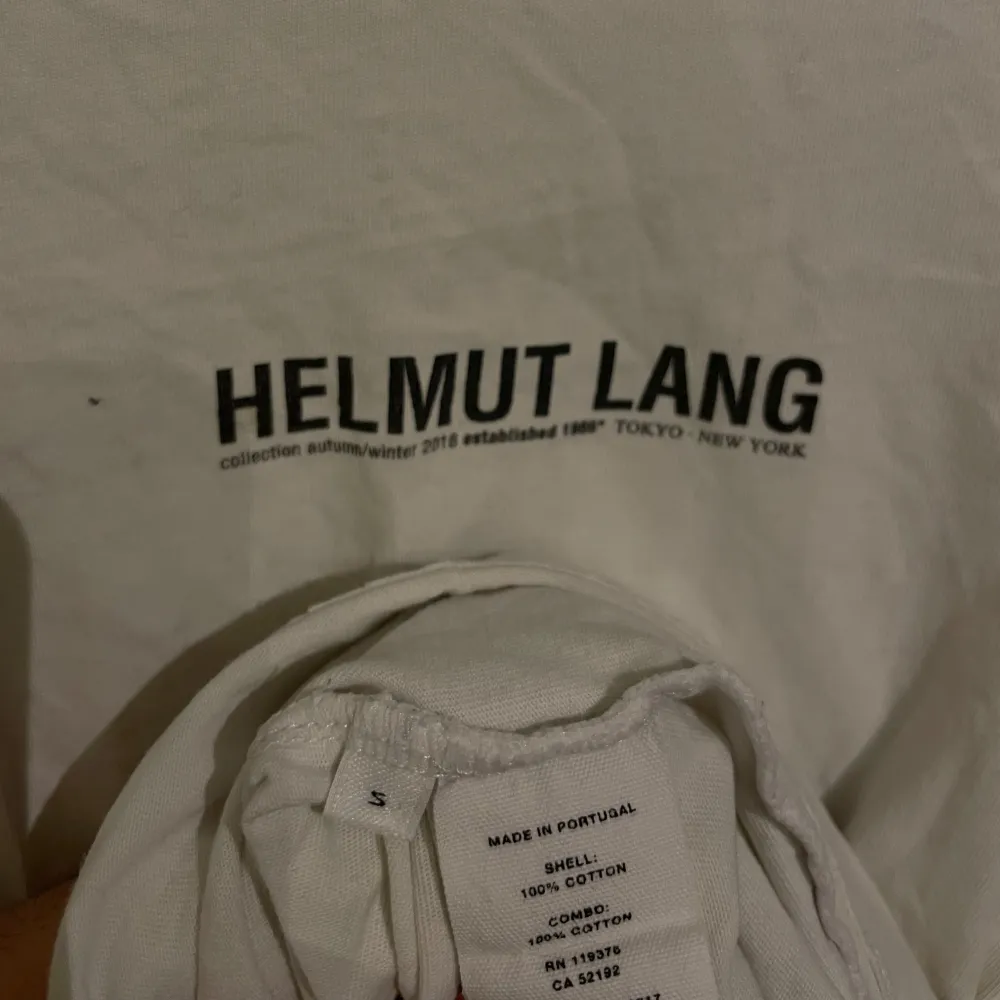 Riktigt modern vit Helmut Lang T-shirt i bra skick, i storlek S. Går att matcha till alla outfits med en elegant och tidlös logga vid bröstet som inte är för mycket. Perfekt passform och väldigt skön och mjuk att ha på sig, nypris ca 2500kr. . T-paidat.