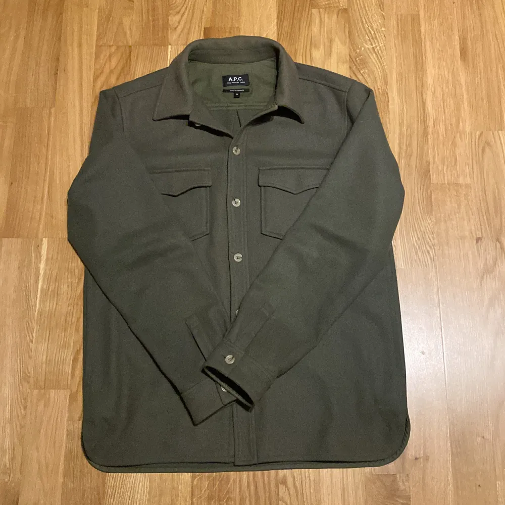 Riktigt snygg overshirt från A.P.C i kamouflage-grön färg! Passar perfekt till alla höst och vinter-outfits och är väldigt skön! Gjord av kashmir, ull och polymade så den är väldigt varm. Nypris ca 6000 så detta är ett riktigt bra kap! Storlek M och mycket bra skick. Tveka inte på att höra av er! 🪐❄️🌟. Jackor.