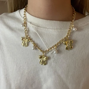 Guld halsband  - Guld halsband med rosetter, har gjort det själv. Vet ej om de är rostfritt!!