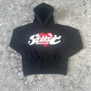 Säljer min feta Stüssy hoodie, coolt tryck i vitt och rött på framsidan. Perfekt för en avslappnad stil och passar bra allt. Storlek L men passar som en S/M. Super varm och tjockt material/ heavyweight! Perfekt för höst och vinter! Inga mer defekter förutom några små repor på den röda delen av hoodien, märks knappt! 