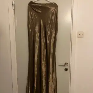 Säljer en elegant khaki/brunfärgad långkjol i satin från Boohoo. Kjolen är superskön, slät och superglansig och är väldigt lyxig. som ger en lyxig känsla. Köptes i sommar men är aldrig använt (prislapp kvar) då jag önskat en lösare passform. Jag är 178-9 cm och den kommer över midjan och precis vid anklarna (tall). Storleken är UK 16, EUR 44, US 12. Hör av er för prisförslag eller andra frågor! 🌸