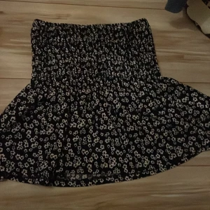Svart blommig kjol från Gina Tricot - Säljer en superfin svart kjol med vita blommor från Gina Tricot. Den har en elastisk midja som ger en bekväm passform. Perfekt för både vardag och fest! 🌸 storlek xs säljes för 100kr 