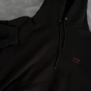 Svart hov1 hoodie - Säljer en svart hoodie från hov1 med en cool design. Den har en liten röd krona på framsidan och ett stort tryck på baksidan med texten 'UNTIL NEXT TIME TOUR'. Perfekt för höst och vinter, och den är i bra skick men finns små lagningar från hål. Skön och stilren för alla fans! 💕