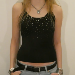 Svart glittrig festtopp - Snygg svart linnetopp med glittriga detaljer framtill. Storlek S.