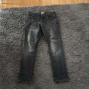 Grå jeans från Jack & Jones - Säljer ett par snygga grå jeans från Jack & Jones i bra skick. De har en klassisk femficksdesign och en bekväm passform. 
