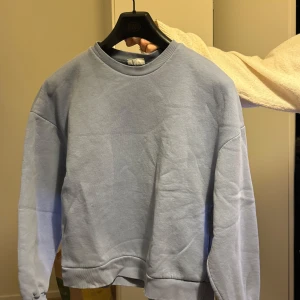 Ljusblå sweatshirt - Säljer en ljusblå sweatshirt i bra skick. Den är perfekt för både vår och höst med sin mjuka och bekväma passform. Tröjan har långa ärmar och en rund halsringning. Perfekt för en avslappnad stil!