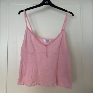 Sött rosa linne - Väldigt sött babyrosa linne 🩷💘Y2K vibbar då den är vintage! Med rosett o spetskant framtill🌸Storlek L (42-44). Jättefint skick, som ny! Sååå söt till typ jeans eller en kjol 🫶🏻