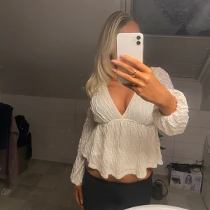 Vit blus från Shein - Säljer en superfin vit blus från Shein i storlek S. Den har en v-ringad design och långa ärmar med ett lätt volangmönster. Perfekt för både vardag och fest! Säljer då den inte kommer till användning. Kom privat vid frågor ❣️