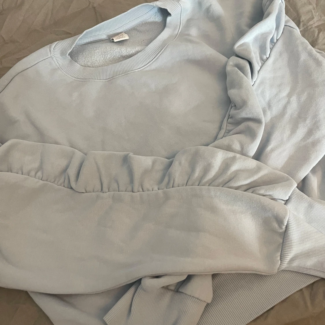 Ljusblå tröja med volanger på ärmarna från Lindex