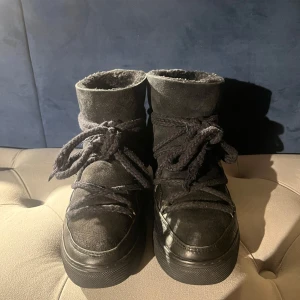 Svarta vinterskor från Inuikii - Säljer ett par svarta vinterskor från Inuikii. Bra skick, de är absolut lite slitna men inte så markant att man tänker på det. De är använda förra vintern men inte använt de sedan dess. De är gjorda av skinn och mocka med en mysig insida. Skorna har snörning framtill och en robust sula, perfekta för kalla dagar. Passar både till vardags och lite finare tillfällen. De är i storlek 39 men passar mig som brukar ha 38. Nypris ca: 3000, Priset går att diskuteras. 
