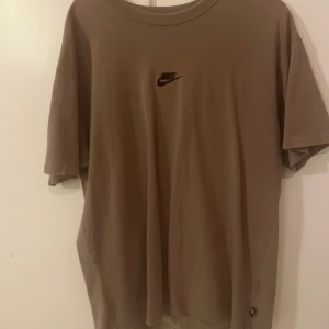 Beige t-shirt från Nike - Säljer en snygg beige oversized t-shirt från Nike i mycket bra skick. Den har en klassisk design med Nike-loggan broderad💕står S i storlek men skulle säga att de mer är M!