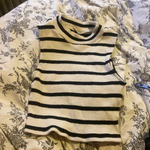 Randig ärmlös topp från Gina Tricot - Säljer en superfin ärmlös topp från Gina Tricot i storlek M. Den är randig i svart och vit med en ribbad struktur. Bra skick, säljer för 150+ frakt🌸