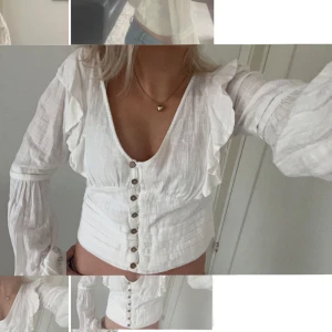 Vit blus med knappar - Säljer en superfin vit blus med knappar framtill. Den har långa ärmar med volangdetaljer och en v-ringad hals. 💕