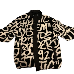 Svartvit pälsjacka - Säljer en unik svartvit pälsjacka med coolt graffiti-mönster i storlek Xl. Perfekt för att sticka ut i mängden och hålla sig varm samtidigt. Aldrig använd, 