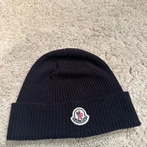 Moncler  - Moncler mössa nya modellen. One size passar alla. Pris 1399kr kvitto finns! Går att köpa till machande halsduk för 999kr 