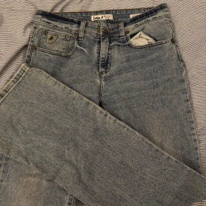 Blå lågmidjade jeans från Lois - Säljer ett par snygga blå jeans från Lois i bra skick. De har en klassisk femficksdesign med en cool sliten detalj på ena fickan. Perfekta för en avslappnad vardagslook. Passar till både sneakers och boots! Midjemått= 37cm Grenhöjd= 23cm Innerbenslängd=80cm🩷