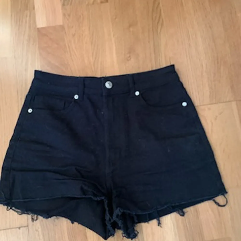 Säljer ett par svarta jeansshorts från Divided i bra skick. De är högmidjade med fransiga kanter och har en klassisk femficksdesign. Perfekta för sommardagar eller festivaler! 🖤. Shorts.