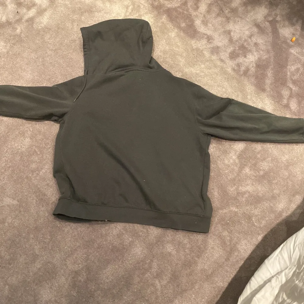 Säljer en svart hoodie med coolt vitt tryck på bröstet. Den har en dragkedja framtill och en skön huva. Perfekt för höst och vinter när du vill hålla dig varm och se stilren ut. Passar både till vardags och chillkvällar. Nypris 800-1000, mitt pris 399. Neuletakit & Villapaidat.