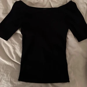 Svart ribbad topp från Lindex - Snygg svart ribbad topp från Lindex i storlek M. Den har en offshoulder-design som ger en stilren look. Perfekt för både vardag och fest! 🖤