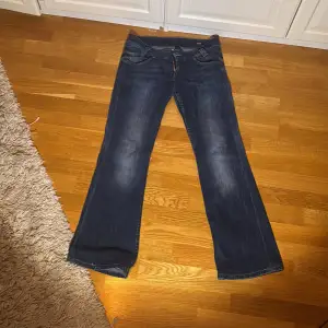 Säljer ett par Lågmidjade mörkblå jeans från Lee i bra skick. De har en klassisk femficksdesign och en bootcut passform som funkar till alla tillfällen. Perfekta för både vardag och fest! 🕺