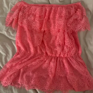 Rosa offshoulder topp från Gina Tricot - Säljer en superfin rosa offshoulder topp från Gina Tricot. Den är i spets och har en luftig och romantisk stil, perfekt för sommardagar. Toppen har en elastisk kant upptill för en bekväm passform. Perfekt för en somrig look! 🌸