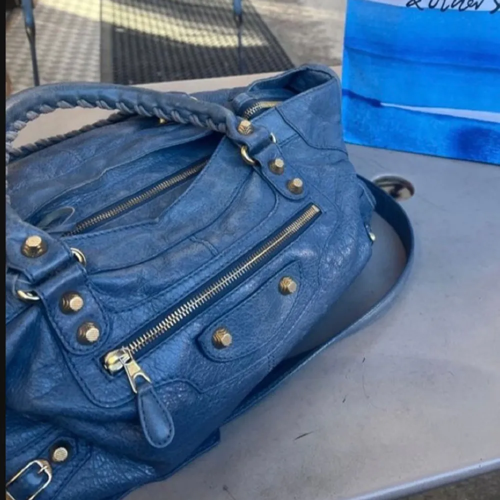 Intressekoll på min äkta balenciaga city bag i den drömmigaste blå färgen! Axelrem och spegel ingår, och har inga synliga defekter förutom en liten repa på spegeln på sista bilden. Köptes på Vestiaire så inget kvitto men betalade för äkthetskontroll. Andra bilden är lånad men skulle säga det är exakt samma modell, kom priv för mer detaljer. Väskor.