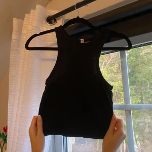 Svart ribbad linnetopp från H&M - Säljer en svart ribbad linnetopp från H&M i storlek XS. Perfekt för sommardagar eller som ett basplagg i garderoben. Toppen är ärmlös och har en tight passform som framhäver figuren. Aldrig använt då jag har 2 likadana🌟
