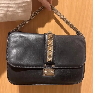 Valentino glam lock - Svart valentino glam lock väska. Flitigt använd men i ok skick. Ett av de små banden som håller i kedjan till väskan har gått sönder och på insidan kan man se små sömmar då jag lagat väskan tidigare. 