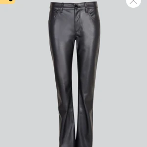 Svarta skinnbyxor - Snygga svarta skinnbyxor i bootcut. Perfekta för en cool och stilren look. De har en knapp och dragkedja framtill och är högmidjade för en bekväm passform. Passar både till vardags och fest! Knappt använda!!