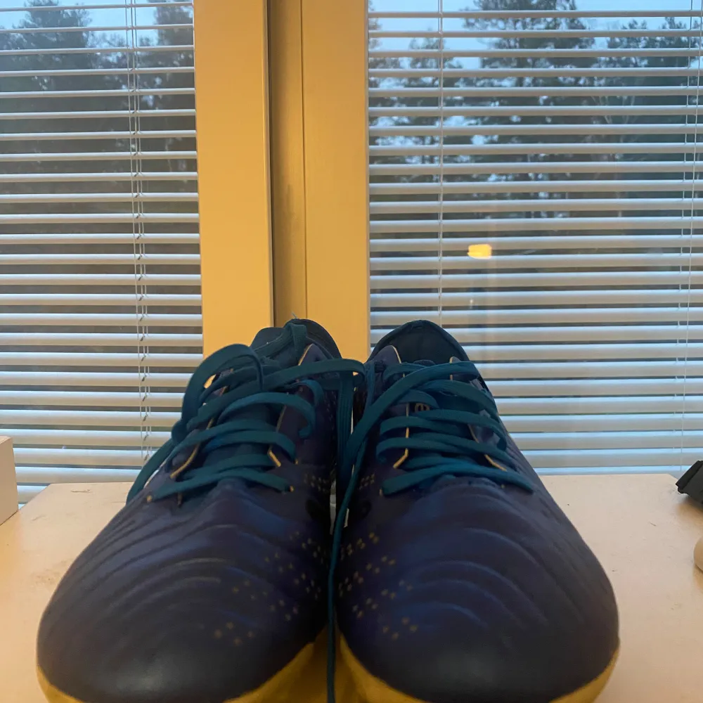 Säljer ett par blå Nike Tiempo fotbollsskor i mycket bra skick. Skorna har en snygg vit Nike-logga på sidan och är perfekta för fotbollsträning. De har snörning för en bra passform och är designade för att ge bra grepp på planen.. Skor.