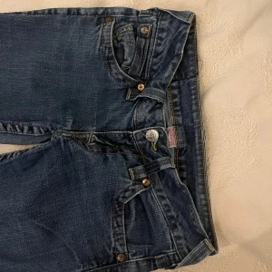Lågmidjade true religion jeans  - Lågmidjade och bootcut jeans från true religion w27/S. Slitna nertill 