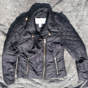 Svart MC Pufferjacka från NLY Trend - Säljer en snygg svart MC-inspirerad pufferjacka från NLY Trend i storlek 36. Jackan har quiltade detaljer och dragkedjor fram och vid ärmsluten. Perfekt för höst och vår när du vill ha en cool look. Tillverkad i 100% polyester.