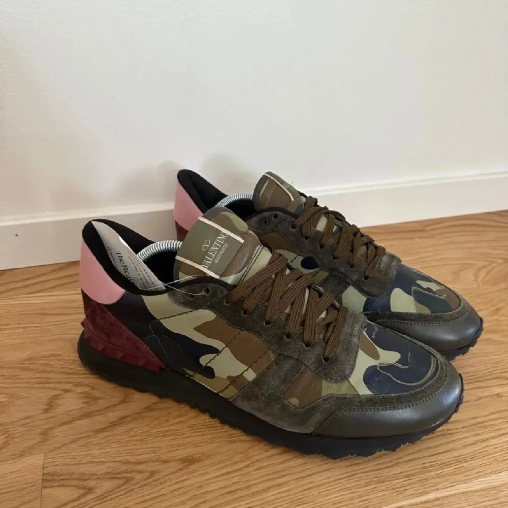 Säljer ett par snygga Valentino Garavani sneakers i camouflage. De har en cool mix av gröna och bruna nyanser med rosa detaljer på hälen. Skorna har snörning och är i bra skick. Säljer på grund av att dom är för stora. Nypris 7000 kr säljer för 2799. Skor.