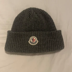 Moncler Mössa  - Säljer nu en grå moncler mössa perfekt till vinter! Skicket är som nytt och har inga skador 