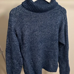 Blå stickad polotröja från Deval - Mysig blå stickad polotröja från Deval i storlek L. Perfekt för kyliga dagar med sin varma och bekväma passform. Tröjan har långa ärmar och en klassisk polokrage som håller dig varm hela vintern. Ett måste i garderoben för alla som älskar stil och komfort! 💙