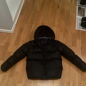 Svart dunjacka från Tommy Hilfiger - Säljer en snygg svart dunjacka från Tommy Hilfiger. Nypris 1400kr, säljer för att den passar inte min stil längre