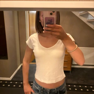 Vit croppad t-shirt - Säljer en enkel och stilren vit croppad t-shirt. Den är köpt för 200 kr 