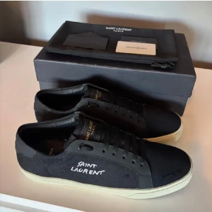 Svarta sneakers från Saint Laurent - Säljer dessa riktigt feta Saint Laurent skor i storlek 42. Skicket är fortfarande väldigt bra efter 2-3 gånger av användning (Sulan är lite smutsig) Skriv direkt vid frågor eller prisförslag så löser vi en bra deal! OBS: BOX OCH DUSTBAG INGÅR ENBART!