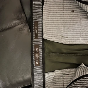 Svarta skinny fit byxor - Säljer ett par mörkgröna skinny fit byxor/ chinos från Michael Kors . Byxorna har en stilren design och är perfekta för både vardag och fest. De är bekväma och har en snygg passform.  Perfekta för höst och vår!