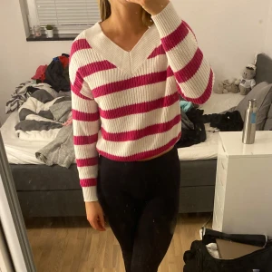 Randig tröja i rosa och vit - Säljer en superfin randig tröja i rosa och vit. Den har en v-ringad hals och långa ärmar, perfekt för både vår och höst. Tröjan är i bra skick och passar perfekt för en casual look. Skön och mysig att ha på sig!