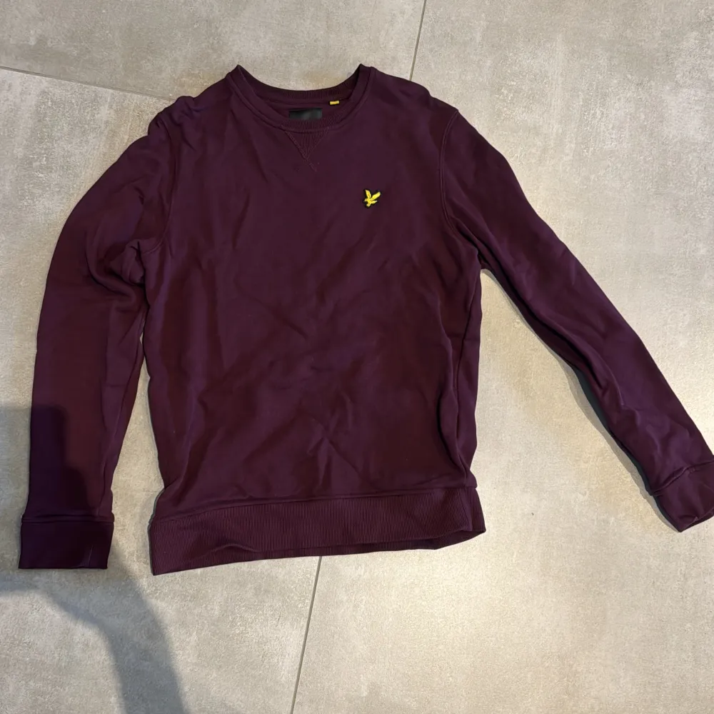 Säljer en snygg vinröd tröja från Lyle & Scott i storlek S. Tröjan har en liten gul logga på bröstet och är perfekt för både höst och vinter. Den är i mycket bra skick!. Tröjor & Koftor.