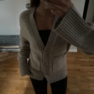 Beige stickad kofta - Säljer en supermysig beige stickad kofta från Gina tricot. Perfekt för höst och vinter med sina långa ärmar och stora knappar. 