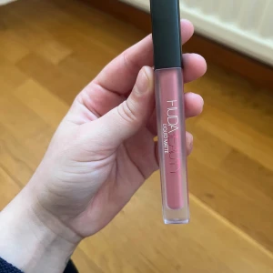 Huda Beauty Liquid Matte Läppstift - Säljer ett Huda Beauty Liquid Matte läppstift i färgen Bombshell. Fullsize . Aldrig använd.