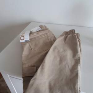 Säljer ett par snygga beige cargopants från Only. De har en tight passform och är perfekta för både vardag och fest. Byxorna har praktiska fickor på sidorna och en elastisk midja för extra komfort. Perfekta för höst och vår! Byxorna går att skicka med Schenker föŕ 59 kr.