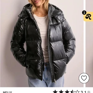 Svart glansig pufferjacka från Nelly - Säljer en svart glansig pufferjacka från Nelly i storlek L. Jackan har en dragkedja framtill och är perfekt för kalla dagar. Aldrig använd nästan och passar mig som är strolek s-m i vanliga fall