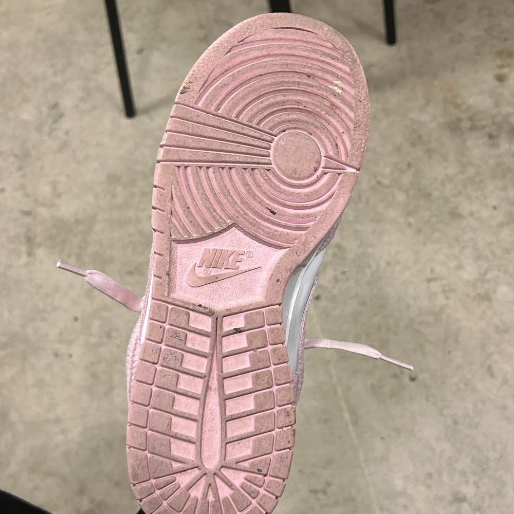 Säljer ett par snygga Nike Dunk sneakers i rosa och vitt. De är i mycket bra skick och har en klassisk design med snörning. Perfekta för vår och sommar. Sköna att gå i och riktigt trendiga just nu!. Skor.