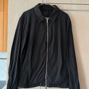 Svart jacka från New Look - storlek M - Säljer en stilren svart jacka från New Look i storlek M. Jackan har en dragkedja framtill och klassisk krage. Perfekt för höst och vår, med en enkel och tidlös design. Passar både till vardags och lite mer uppklädda tillfällen.