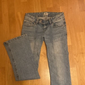 Blå jeans från 157 - Säljer ett par jättesnygga lågmidjade bootcut jeans. De är i bra skick men har en liten fläck på baksidan av benet, men det är inget man tänker på. Skriv om du har någon fråga!
